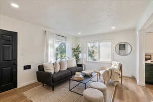 Living room featuring a textured ceiling and light hardwood / wood-style flooring