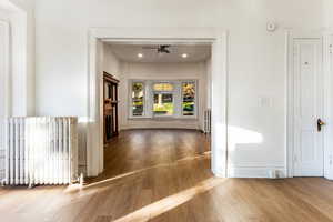 Dining featuring radiator and wood-type flooring