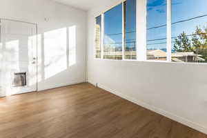 Empty room with wood-type flooring and heating unit