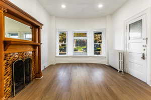 Living room featuring radiator heating unit and dark wood-type flooring