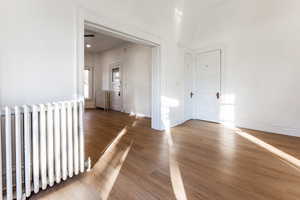 Dining room with radiator heating unit and wood-type flooring