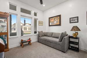 Living room with ceiling fan and light colored carpet