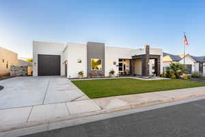 Contemporary home featuring a front lawn and a garage