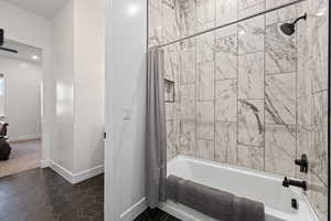 Bathroom featuring shower / tub combo with curtain and tile patterned flooring