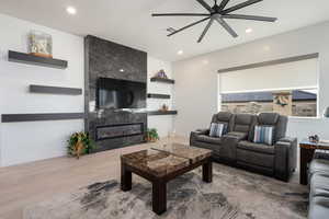 Living room with a tiled fireplace and hardwood / wood-style flooring