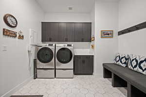 Clothes washing area with washer and clothes dryer and cabinets