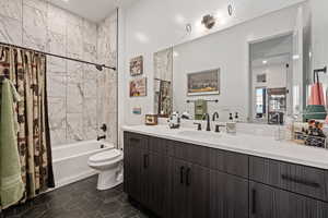 Full bathroom with toilet, vanity, shower / bath combination with curtain, and tile patterned floors