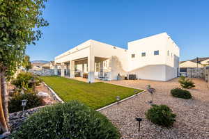 Back of house featuring a lawn, central AC, and a patio