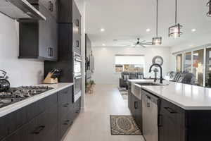 Kitchen featuring decorative light fixtures, a healthy amount of sunlight, light wood-type flooring, and stainless steel appliances