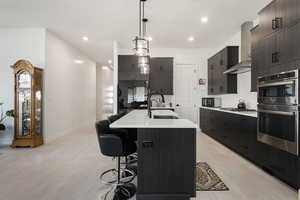 Kitchen featuring a kitchen breakfast bar, sink, light hardwood / wood-style flooring, and an island with sink