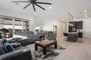 Living room with ceiling fan, light hardwood / wood-style flooring, and sink