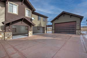 View of front facade featuring a garage and an outdoor structure