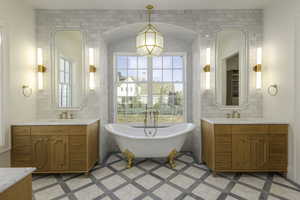 Bathroom featuring vanity, a bath, and tile walls