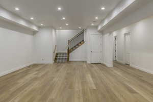 Basement with light hardwood / wood-style flooring