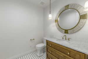 Bathroom featuring vanity, toilet, decorative backsplash, and tile walls