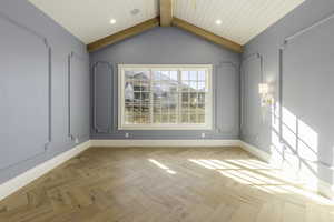 Spare room featuring vaulted ceiling with beams, light parquet floors, and wooden ceiling