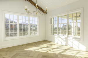 Unfurnished dining area featuring wooden ceiling, vaulted ceiling with beams, a notable chandelier, a mountain view, and light parquet floors