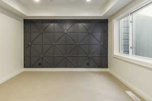 Carpeted spare room with a tray ceiling