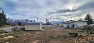 View of yard with a mountain view and a shed