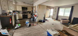 Kitchen featuring cream cabinetry, rail lighting, stainless steel appliances, and tasteful backsplash