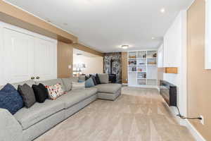 Carpeted living room featuring a wood stove