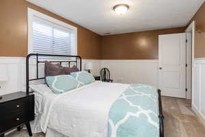 Bedroom featuring light colored carpet and a textured ceiling