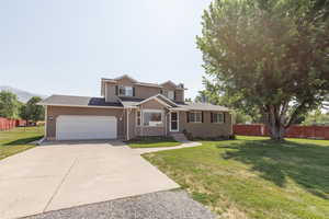 View of front facade with a front lawn and a garage