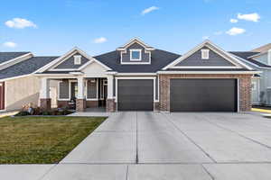 Craftsman inspired home featuring a porch, a garage, and a front lawn