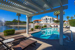 View of pool with a water view, a pergola, and a patio