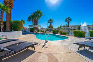 View of community outdoor swimming pool with a patio