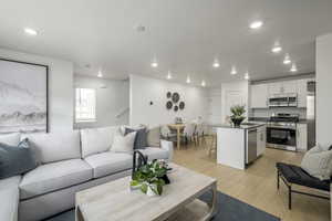 Living room featuring a textured ceiling, light hardwood / wood-style floors, and sink