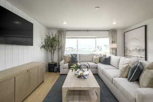 Living room featuring wood walls, a textured ceiling, and light hardwood / wood-style floors