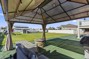 View of patio / terrace featuring a playground, a shed, an outdoor living space with a fire pit, and a gazebo