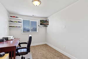 Office area with a textured ceiling and light colored carpet