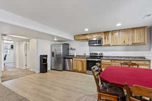 Kitchen with sink, light hardwood / wood-style floors, and stainless steel appliances