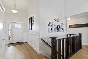 Entrance foyer featuring high vaulted ceiling and light hardwood / wood-style floors