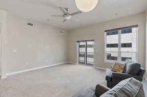 Living room with light colored carpet and ceiling fan