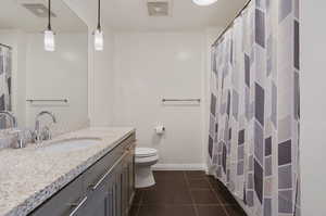 Bathroom featuring toilet, vanity, and tile patterned flooring