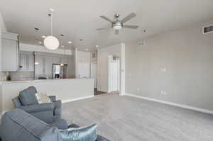 Carpeted living room with ceiling fan