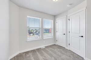 Unfurnished bedroom with light carpet