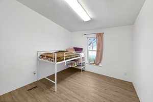 Bedroom with hardwood / wood-style floors and a textured ceiling