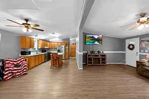 Interior space with sink, vaulted ceiling, ceiling fan, and light hardwood / wood-style flooring