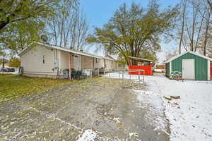 Snow covered house featuring a storage unit