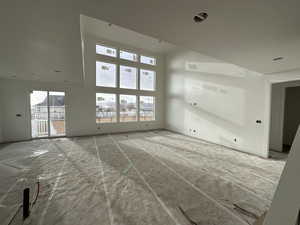 Unfurnished living room featuring a high ceiling