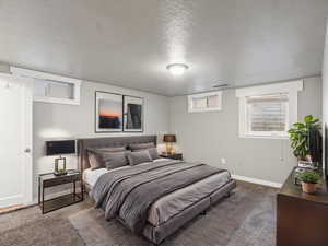 Carpeted bedroom with a textured ceiling