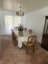 Dining space with carpet flooring and a notable chandelier