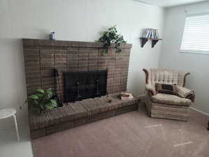 Living room featuring carpet floors and a brick fireplace