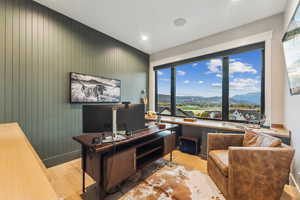 Office featuring a wealth of natural light, light hardwood / wood-style flooring, and wooden walls