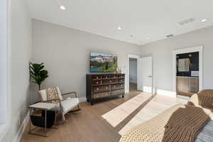 Bedroom featuring ensuite bathroom and light wood-type flooring