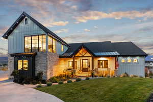 Modern inspired farmhouse with a porch and a lawn